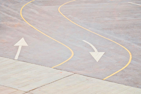 Yellow traffic curved lines and white arrow symbol on the road.