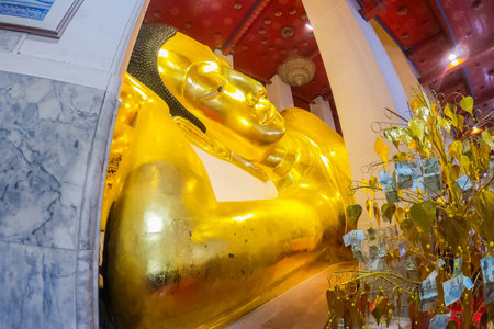 Big gold buddha statue at Wat Phra Non Chaksi, Singburi, Thailand. Beautiful of historic city at...