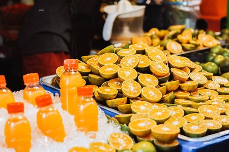 Fresh orange juice in bottle with Orange slices put on the table at local market.の写真素材