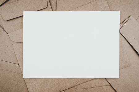Top view of Brown paper envelope with white paper. Flat lay of Many brown paper envelopes overlaid. Stationery minimalism style.の写真素材