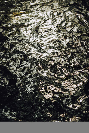 Close-up of water with reflex sunlight. River surface background.