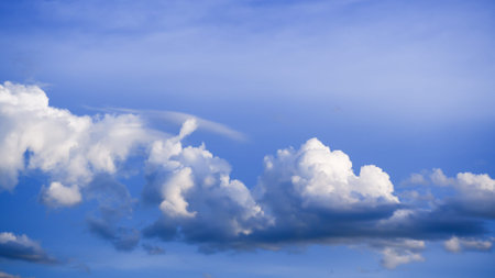 Blue sky with fluffy white clouds. Beautiful nature background.