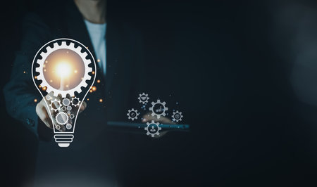 Businessman touch of virtual lightbulb brain idea with tablet. New ideas inspiration and innovation concept.の写真素材