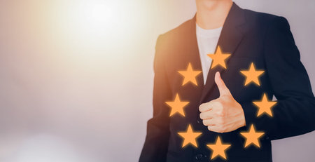 Customer reviews 5 Stars. Customer service evaluation and satisfaction. Businessman hand making good...