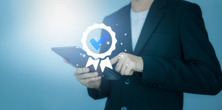Businessman with tablet and sign of the top service and correct. ISO certification, Guarantee, Quality assurance, Standards and standardization concept. Customer service evaluation and satisfaction.の写真素材