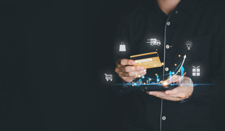 Businessman hand hold gold credit card and smartphone with hologram. Online shopping and Futuristic...
