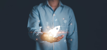Startup concept. Businessman hand with rocket launch icon and network connection on hologram virtual interface. Fast business success.の写真素材