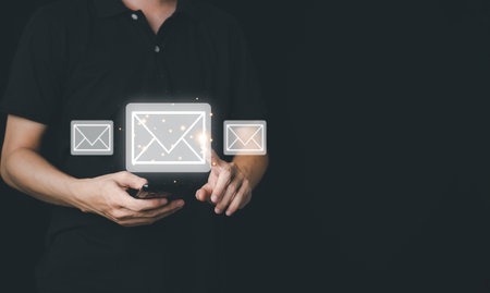 Businessman hands hold smartphone and touch email icon and send e-mail or newsletter. Electronic mail marketing and online working internet network concept.の写真素材