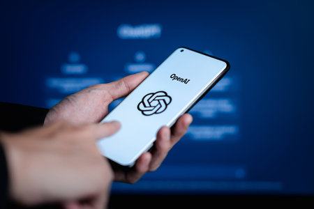 Phayao, Thailand - January 17 2023 : ChatGPT, Hand hold smartphone with AI chatbot by OpenAI open on website on laptop display screen on the background.のeditorial素材