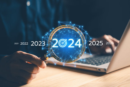 Business growing in 2024. Businessman hand hold magnifying glass with laptop. New business startup...