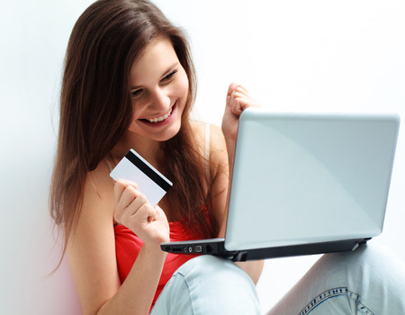 A Happy  Woman Holding a credit card and shopping from the internetの写真素材