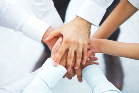 International business team showing unity with their hands together