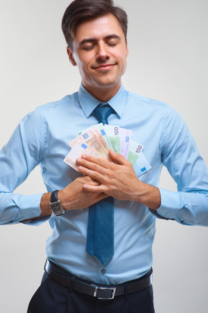 Businessman celebrating money income against white backgroundの写真素材