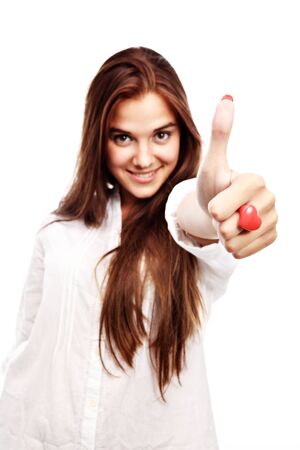 Portrait of  young woman gesturing a thumbs up sign isolated  on whiteの写真素材