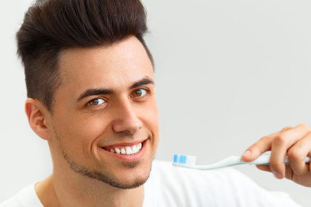 Man with toothbrush. Man brushing his teeth and smiling