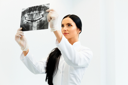 Female Dentist Looking at Dental Xray in Clinicの写真素材