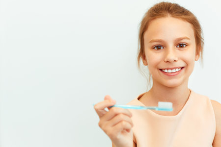 Little girl holding toothbrush.  Happy girl brushing her teeth