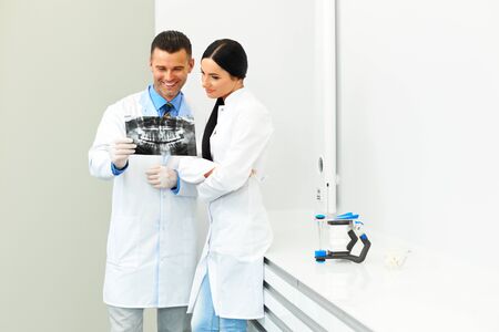 Dentist and female assistant are discussing dental X Ray imageの写真素材