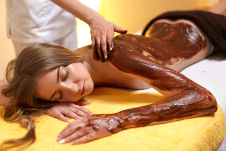 Spa Woman. Young Woman Gets Chocolate Body Mask at Beauty Salonの写真素材