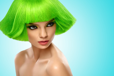 Woman Hair. Fashion Stylish Beauty Portrait With Green Hair. Beautiful Girl's Face Close-up. Haircut. Hairstyle. Fringe. Professional Makeup. Make-up. Vogue Style Woman. Against blue backgroundの写真素材