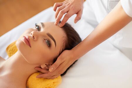 Spa Woman. Beautiful Young Woman Getting a Face Treatment at Beauty Salon. Face Massageの写真素材