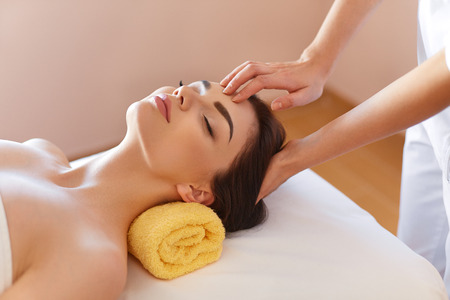 Spa Woman. Beautiful Young Woman Getting a Face Treatment at Beauty Salon. Face Massageの写真素材
