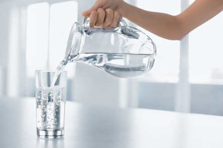 Drink Water. Woman's Hand Pouring Fresh Pure Water From Pitcher Into A Glass. Health And Diet Concept. Healthy Lifestyle. Healthcare And Beauty. Hydratation.