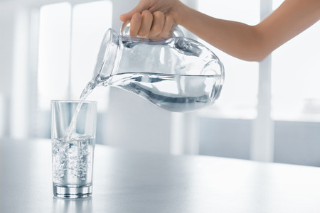 Drink Water. Woman's Hand Pouring Fresh Pure Water From Pitcher Into A Glass. Health And Diet Concept. Healthy Lifestyle. Healthcare And Beauty. Hydratation.