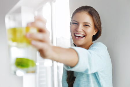 Healthy Lifestyle Concept, Diet And Fitness. Smiling Woman Drinking Refreshing Water With Fresh Organic Lemon , Lime, Mint. Detox Vitamin-fortified Water. Healthy Eating, Food. Vitamin, Diet Concept.の写真素材