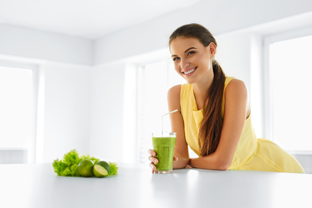 Healthy Meal. Happy Beautiful Smiling Woman Drinking Green Detox Vegetable Smoothie. Healthy Lifestyle, Food And Eating. Drink Juice. Diet, Health And Beauty Concept.の写真素材