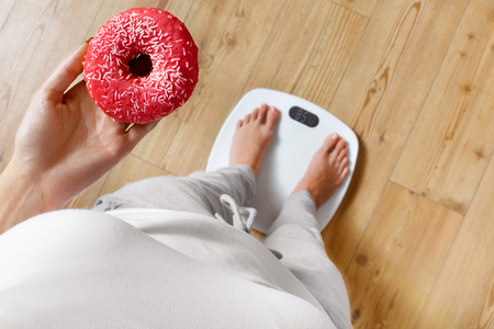 Diet. Woman Measuring Body Weight On Weighing Scale Holding Donut. Sweets Are Unhealthy Junk Food. Dieting, Healthy Eating, Lifestyle. Weight Loss. Obesity. Top Viewの写真素材