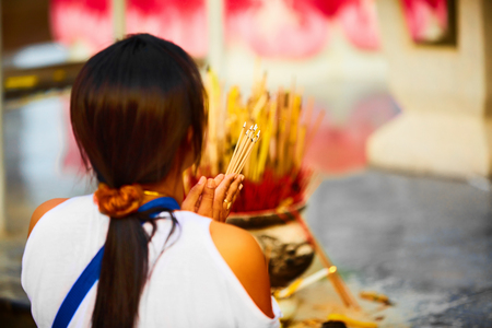 Religion. Close Up Of Young Asian Woman Praying Buddha Holding Burning Incense Aroma Sticks In Hands At Wat Phra Yai, The Big Buddha Temple At Koh Samui, Thailand. Buddhism. Belief And Faith.の写真素材