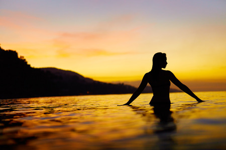 Healthy Lifestyle, Health Background. Silhouette Of Beautiful Young Woman Enjoying Sea Water And Sunset. Summer Travel Holidays Vacation. Happiness, Freedom, And Peace, Wellness, Body Care Concept.の写真素材