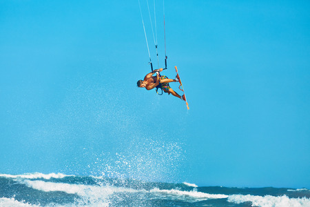 Recreational Water Sports Action. Healthy Man ( Surfer ) Kiteboarding ( Kite Surfing ) On Waves In Sea, Ocean. Extreme Sport. Summer Fun, Vacation. Active Lifestyle. Leisure Sporting Activity. Hobbyの写真素材