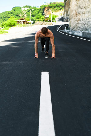 Athletics. Athletic Man With Fit Muscular Body In Starting Position For Running On Road. Handsome...