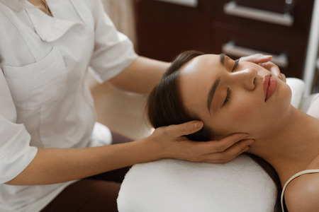 Spa Massage. Closeup Of Beautiful Healthy Woman Getting Face Massage At Salon. Female Enjoying Facial Beauty Treatment While Masseur Hand Massaging Her Head. Skin Care Concept. High Resolution Imageの写真素材