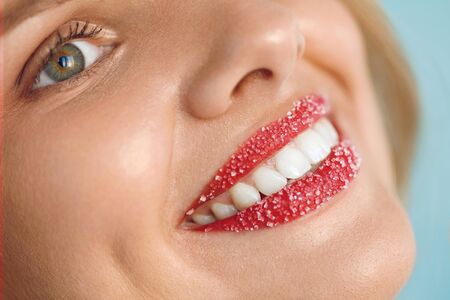 Woman With Beautiful White Smile And Lip Scrub On. Closeup Of Smiling Girl's Beauty Face With Healthy White Teeth And Plump Full Lips With Sugar Lips. Lip Care Cosmetics Concept. High Resolution Imageの写真素材