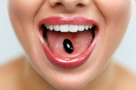 Vitamins And Supplements. Close Up Of Beautiful Woman Opened Mouth Holding Vitamin Pill On Tongue. Close-up Of Smiling Girl Taking Medicine. Healthy Diet Nutrition, Health Concept. High Resolutionの写真素材