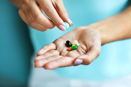 Vitamins And Supplements. Closeup Of Female Hand Holding Variety Of Colorful Pills On Palm. Close-up...