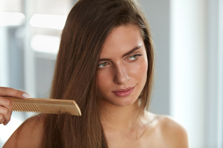 Hair Health And Beauty. Closeup Of Young Woman With Beautiful Healthy Long Hair Hairbrushing After Bath. Portrait Of Sexy Girl In Towel Brushing Using Comb Brush. Healthy Lifestyle. High Resolutionの写真素材