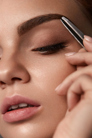 Beauty Woman Makeup. Closeup Of Beautiful Glamorous Sexy Woman Face With Closed Eye Plucking Eyebrow...