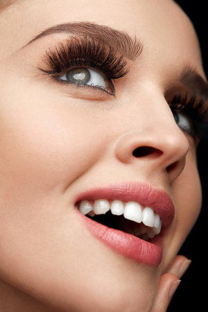Woman Facial Makeup. Closeup Of Beautiful Smiling Female Face With Long Fake Eyelashes, Perfect Make-up. Happy Girl With Fresh Soft Skin, White Teeth And Perfect Smile. Beauty Concept. High Resolutionの写真素材