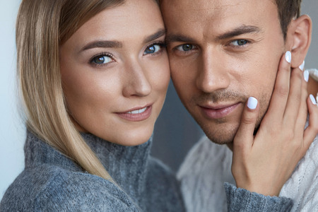 Love And Care. Beautiful Young Couple Embracing Indoors. Portrait Of Attractive Woman With Natural Makeup Touching Handsome Man Soft Face Skin. Sensual Male And Affectionate Female. High Resolutionの写真素材