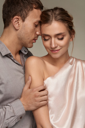 Happy Couple In Love. Handsome Man Gently And Tenderly Touching Beautiful Smiling Woman. Male Close To Sexy Female, Holding Her Arm With Healthy Smooth Silky Soft Skin. Relationships. High Resolutionの写真素材