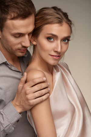 Romantic Couple In Love. Handsome Man Gently And Sensually Holding Beautiful Woman With Perfect Natural Makeup. Male Touching Female Smooth Soft Healthy Skin On Arm. Beauty Cosmetics. High Resolution の写真素材