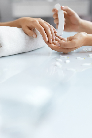 Hands Beauty. Closeup Of Beautiful Woman Hands Receiving Manicure Procedure In Spa Salon. Beautician Filing Healthy Natural Female Nails With Nail File. Nail Care Concept. High Resolutionの写真素材