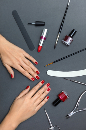 Hands Beauty And Nail Care. Top View Of Beautiful Female Hands With Healthy Nails And Red Nail Polish On Grey Background With Manicure Tools. Closeup Of Female Hands With Nail Tools. High Resolutionの写真素材