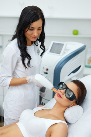 Beauty Procedure. Closeup Of Beautician Using Laser Therapy For Facial Skin Rejuvenation. Beautiful Healthy Woman Face Getting Skin Resurfacing In Spa Salon. Body Treatment. High Resolutionの写真素材