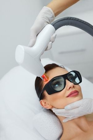 Cosmetology. Closeup Of Beautiful Young Woman Receiving Rejuvenation Treatment In Spa Salon. Medical Worker Doing Skin Resurfacing And Dermabrasion For Female Client. Skin Procedures. High Resolutionの写真素材