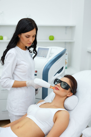 Beauty Procedure. Closeup Of Beautician Using Laser Therapy For Facial Skin Rejuvenation. Beautiful Healthy Woman Face Getting Skin Resurfacing In Spa Salon. Body Treatment. High Resolutionの写真素材